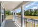 Inviting porch with white railings offers stunning views of the green landscape and blue sky at 426 Clear Lake Dr., Conway, SC 29526