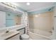 Bright bathroom featuring a tub with seashell shower curtain, vanity with sink, and ample lighting at 4619 S Ocean Blvd. # 501, North Myrtle Beach, SC 29582