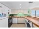 Bright kitchen with white cabinetry, a stainless steel sink, and all modern appliances, including a washer and dryer at 4619 S Ocean Blvd. # 501, North Myrtle Beach, SC 29582