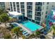 Aerial view of a turquoise pool surrounded by lounge chairs, nestled among palms near the beach, ideal for relaxation at 4619 S Ocean Blvd. # 501, North Myrtle Beach, SC 29582