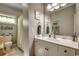 Bathroom with a white vanity, framed mirror, and decorative beach-themed artwork at 4762 Cloister Ln., Myrtle Beach, SC 29577