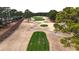 This aerial view showcases a lush green golf course surrounded by mature trees and winding cart paths at 4889 Magnolia Pointe Ln. # 105, Myrtle Beach, SC 29577