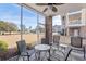 Enjoy outdoor living on this screened porch with ample seating and views of a well-maintained lawn at 4889 Magnolia Pointe Ln. # 105, Myrtle Beach, SC 29577