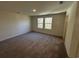 Cozy bedroom features neutral carpet, neutral paint, and a window overlooking a green yard at 536 Tillage Ct., Conway, SC 29526