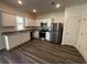 Modern kitchen with white cabinets, stainless steel appliances, granite countertops, and wood-look flooring at 536 Tillage Ct., Conway, SC 29526