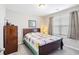 Cozy bedroom featuring a wood-framed bed, side table, dark wood dresser, and natural lighting at 5519 Redleaf Rose Dr., Myrtle Beach, SC 29579