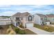 Two-story tan house with a mix of siding and stone details, nestled in a residential neighborhood near a pond at 5519 Redleaf Rose Dr., Myrtle Beach, SC 29579