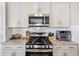 Clean kitchen with stainless steel stove, microwave, and white subway tile backsplash at 5519 Redleaf Rose Dr., Myrtle Beach, SC 29579