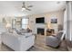 Bright living room with a ceiling fan, fireplace, and comfortable seating area at 5519 Redleaf Rose Dr., Myrtle Beach, SC 29579