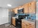 Cozy kitchen featuring knotty wood cabinets, stainless steel appliances, and blue tile backsplash at 5905 South Kings Hwy. # 6215D, Myrtle Beach, SC 29575