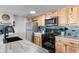 Cozy kitchen featuring knotty wood cabinets, stainless steel appliances, and blue tile backsplash at 5905 South Kings Hwy. # 6215D, Myrtle Beach, SC 29575