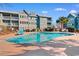 Outdoor pool with lounge chairs and tropical landscaping at condo complex under a sunny sky at 5905 South Kings Hwy. # 6215D, Myrtle Beach, SC 29575