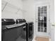 Modern laundry room boasts front loading washer and dryer, shelving, and exterior door at 658 Pamlico Ct., Myrtle Beach, SC 29588