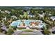 Aerial view of community pool, clubhouse, and surrounding residences surrounded by a lush green canopy of trees at 716 Lapwind Loop, Myrtle Beach, SC 29579