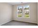 Neutral bedroom with double windows showcasing neighborhood view at 716 Lapwind Loop, Myrtle Beach, SC 29579