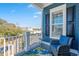 Cozy balcony with blue siding, black shutters, and a comfortable wicker chair with a blue cushion at 7624 Azure Dr., Myrtle Beach, SC 29572