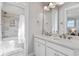 Bathroom with double sink vanity, white cabinets, and a shower-tub combination with tiled walls at 7624 Azure Dr., Myrtle Beach, SC 29572