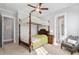 Airy bedroom features four-poster bed with lace canopy, ceiling fan, and en suite bathroom at 7624 Azure Dr., Myrtle Beach, SC 29572