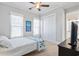 Cozy bedroom with ceiling fan, large windows, and a view into the ensuite bathroom at 7624 Azure Dr., Myrtle Beach, SC 29572