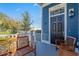 Inviting front porch of a home with wooden bench seating, stained-glass window, and a stylish black door at 7624 Azure Dr., Myrtle Beach, SC 29572