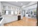 Bright kitchen featuring white cabinets, modern appliances, and hardwood floors leading to an open dining area at 7624 Azure Dr., Myrtle Beach, SC 29572