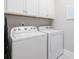 Clean laundry room featuring a white washer and dryer, with white cabinets above and ample space at 7624 Azure Dr., Myrtle Beach, SC 29572