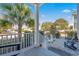 Charming porch with white railings and chairs, offering serene views of lush landscaping and blue skies at 7624 Azure Dr., Myrtle Beach, SC 29572