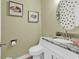 Elegant half bath with a round mirror, oyster paintings and granite countertop at 802 46Th Ave. S, North Myrtle Beach, SC 29582