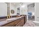 Bathroom featuring dual sinks with granite countertops, wood cabinets, and decorative mirror at 8068 Cortona Dr., Myrtle Beach, SC 29572