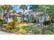 Beautiful single-story home with a tiled roof, decorative entryway, and lush tropical landscaping at 8068 Cortona Dr., Myrtle Beach, SC 29572