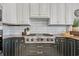 Close-up of the gas stovetop with white subway tile backsplash and custom cabinets at 8068 Cortona Dr., Myrtle Beach, SC 29572