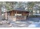 Outdoor kitchen with a stone bar, grill and barstools surrounded by mature trees at 823 Mount Gilead Place Dr., Murrells Inlet, SC 29576