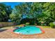 Beautiful in-ground pool with a brick surround, jacuzzi, and lush greenery at 823 Mount Gilead Place Dr., Murrells Inlet, SC 29576