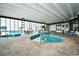 Bright indoor pool area featuring brick floors, a hot tub, and comfortable seating near large windows at 9400 Shore Dr. # 728, Myrtle Beach, SC 29572