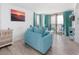 Bright living room with teal furniture and large sliding glass doors to a balcony at 9400 Shore Dr. # 728, Myrtle Beach, SC 29572