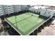 Aerial view of a green outdoor tennis court with parking and partial building view at 9400 Shore Dr. # 728, Myrtle Beach, SC 29572