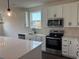 Modern kitchen featuring white cabinets, stainless steel appliances, and quartz countertops at 1001 Cavaletti Ct., Myrtle Beach, SC 29588
