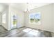 Cozy dining area with wood floors, a modern chandelier, and a large window with picturesque views at 1245 Cypress Shoal Dr., Conway, SC 29526