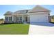 Inviting beige single-story home with a two-car garage and well-manicured lawn at 1245 Cypress Shoal Dr., Conway, SC 29526
