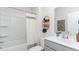 Bright bathroom featuring a shower-tub combo, a gray vanity, and stylish decor on a wall-mounted shelf at 128 Shucking St., Myrtle Beach, SC 29588