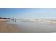Expansive view of the beach with gentle waves, sandy shore, and people enjoying a walk along the water at 128 Shucking St., Myrtle Beach, SC 29588