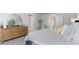 Light-filled bedroom featuring a wooden dresser, a decorative mirror, and neutral colors for a relaxing atmosphere at 128 Shucking St., Myrtle Beach, SC 29588