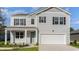 Charming two-story home showcasing a light gray exterior, black shutters, and a convenient attached two-car garage at 128 Shucking St., Myrtle Beach, SC 29588