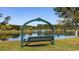 Serene lake view with a charming bench swing in the foreground, creating a peaceful and inviting atmosphere at 128 Shucking St., Myrtle Beach, SC 29588