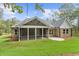 Screened porch with brick exterior and views of the landscaped backyard with green lawn at 1328 Foxtail Dr., Longs, SC 29568