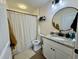Bright bathroom features granite vanity, round mirror, and patterned shower curtain at 160 Leadwood St., Andrews, SC 29510