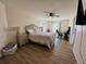 Large bedroom featuring wood-look floors, ceiling fan, lamps, a television, and large window at 160 Leadwood St., Andrews, SC 29510