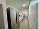 Hallway leading to the laundry room with a stainless steel fridge and wood-look flooring at 160 Leadwood St., Andrews, SC 29510