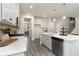 Well-lit kitchen featuring white cabinets, stainless steel appliances, light countertops, and gray wood-look flooring at 1800 Hardwood Ct., Conway, SC 29526