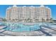 Beautiful outdoor swimming pool in front of condominium complex with palm trees and blue sky at 2151 Bridge View Ct. # 11003, North Myrtle Beach, SC 29582